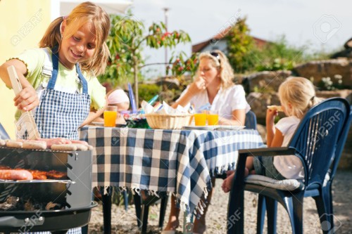 6171491-Family-having-a-barbecue-party-little-kid-at-the-barbecue-grill-preparing-meat-and-sausages-Stock-Photo